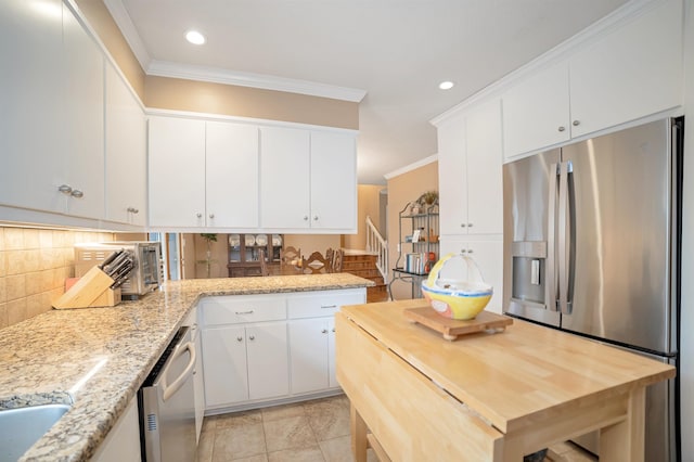 kitchen with crown molding, wood counters, decorative backsplash, and stainless steel appliances