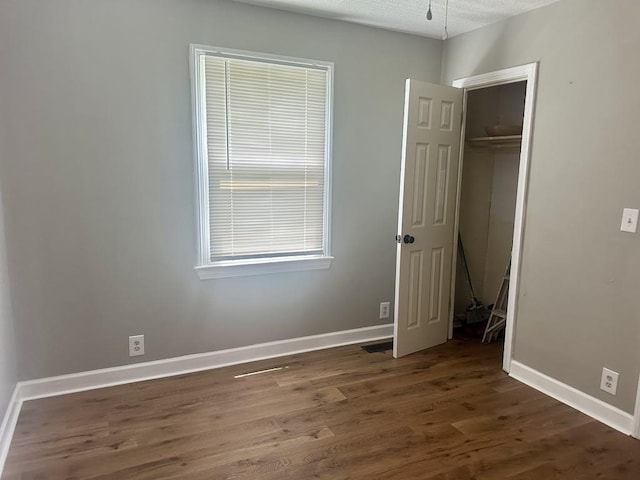  - unfurnished bedroom featuring wood finished floors and a closet