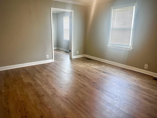  - empty room featuring ornamental molding and dark wood-style floors