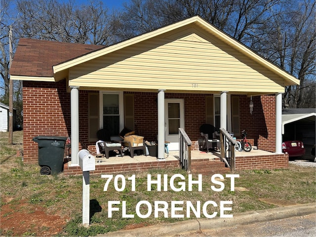 view of front of house featuring covered porch and brick siding