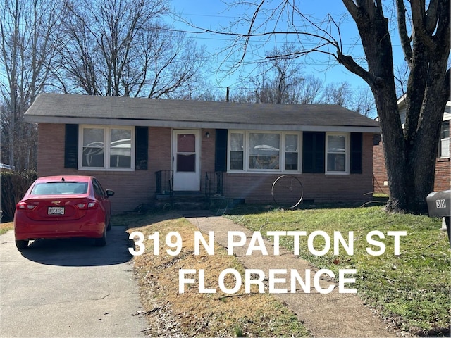 view of front of house with brick siding, asphalt driveway, and roof with shingles