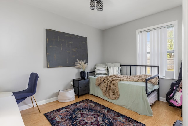 bedroom with baseboards and wood finished floors