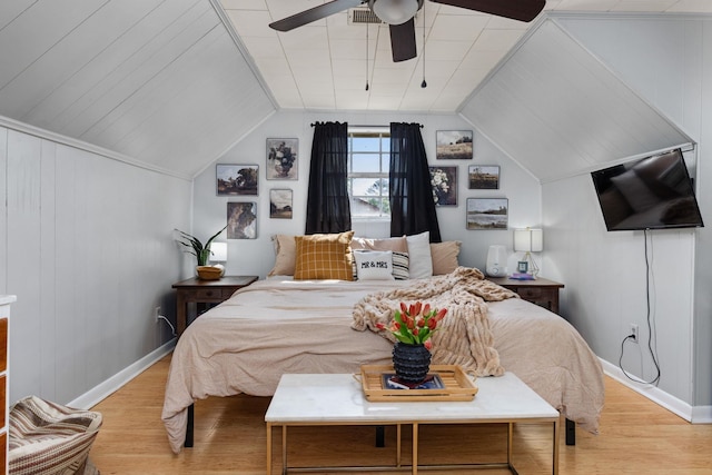bedroom featuring light wood-type flooring, ceiling fan, baseboards, and vaulted ceiling