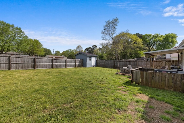 view of yard featuring an outbuilding, a fenced backyard, and a shed