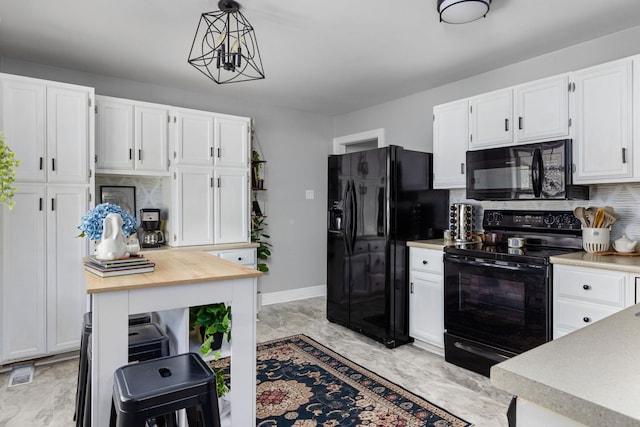 kitchen featuring white cabinets, visible vents, and black appliances