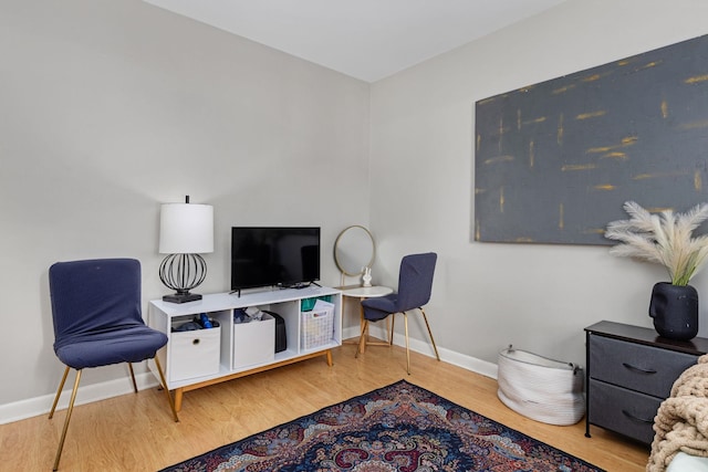 sitting room featuring baseboards and wood finished floors