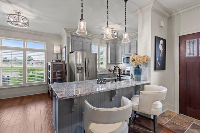  - kitchen featuring appliances with stainless steel finishes, gray cabinets, baseboards, a sink, and ornamental molding