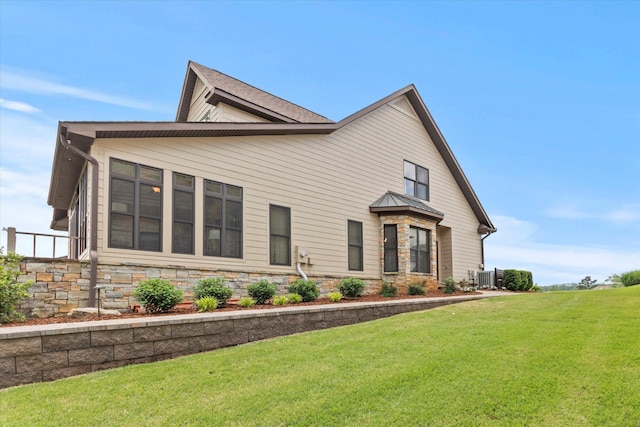  - view of front of property featuring a front yard and central AC unit