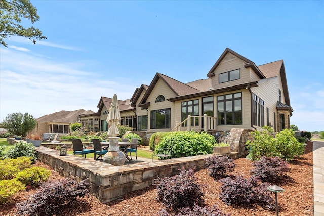 - rear view of house with a patio area and a shingled roof