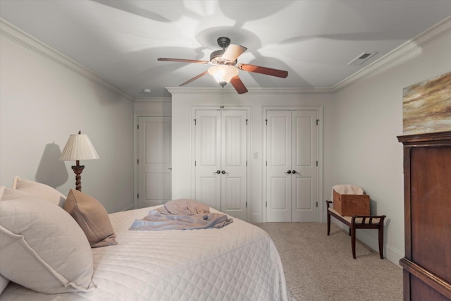  - bedroom with multiple closets, carpet floors, crown molding, and ceiling fan