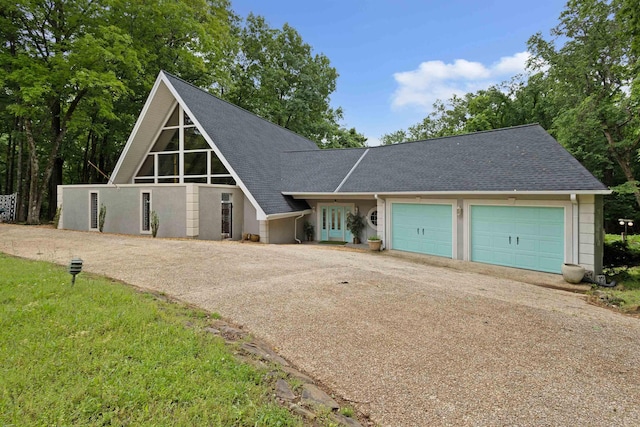  - a-frame style home featuring driveway, roof with shingles, and an attached garage