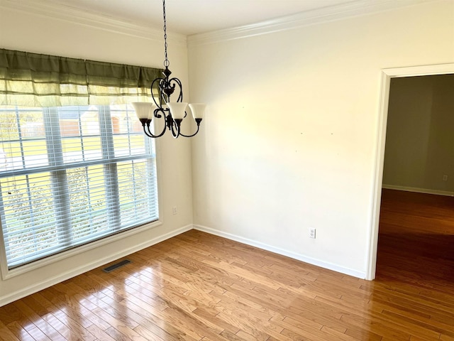 unfurnished dining area with light hardwood / wood-style flooring, an inviting chandelier, and crown molding