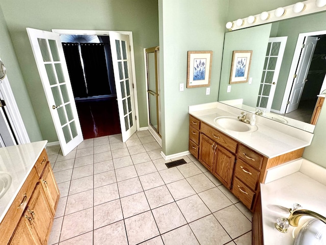 bathroom featuring tile patterned floors, vanity, and a shower with shower door