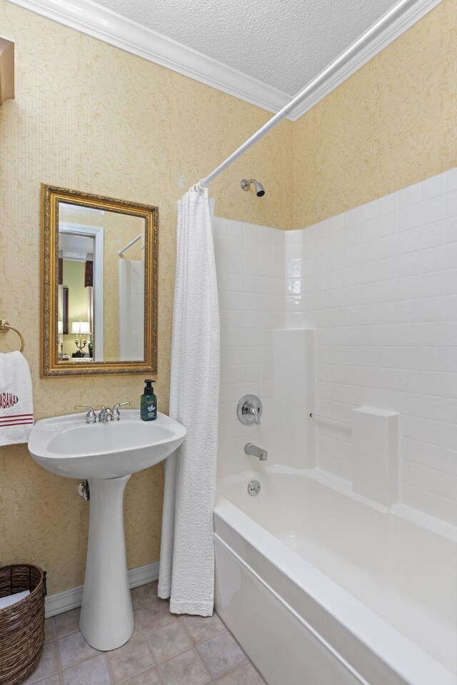 bathroom with shower / tub combo, a textured ceiling, crown molding, sink, and tile patterned flooring