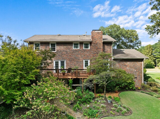 back of property with a yard and a wooden deck