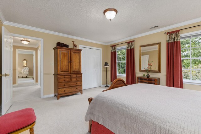 carpeted bedroom with a closet, a textured ceiling, and ornamental molding