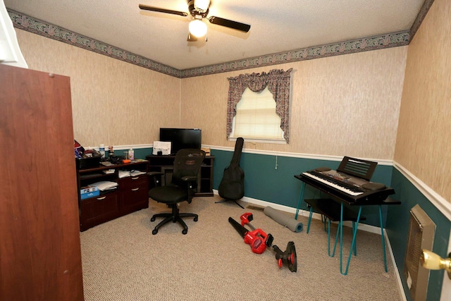 carpeted office space featuring ceiling fan and a textured ceiling