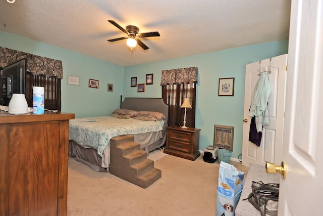 carpeted bedroom featuring ceiling fan and a textured ceiling