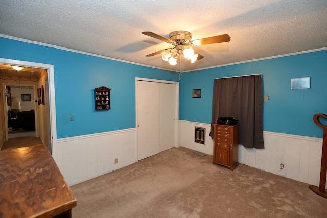 unfurnished bedroom with a textured ceiling, heating unit, ceiling fan, and ornamental molding