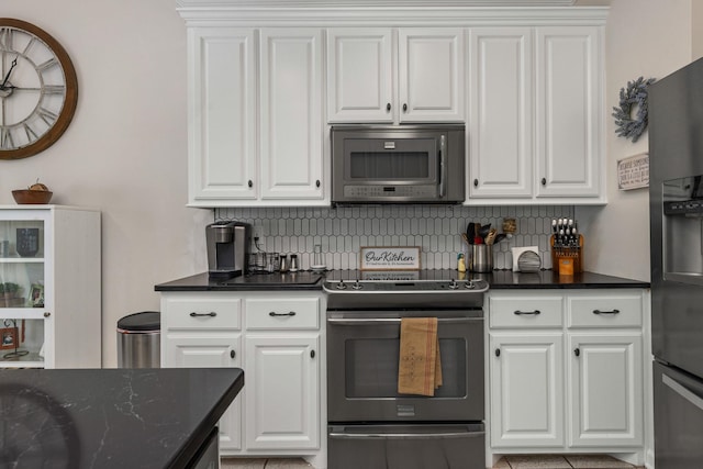  - kitchen featuring stainless steel appliances, backsplash, and white cabinets