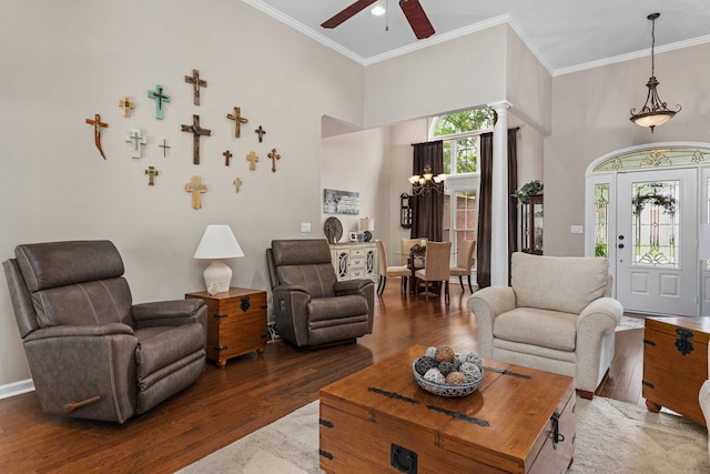  - living room with wood finished floors, ceiling fan, ornamental molding, a towering ceiling, and decorative columns
