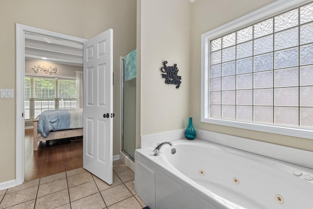  - bathroom featuring connected bathroom, a tub with jets, a shower stall, baseboards, and tile patterned floors