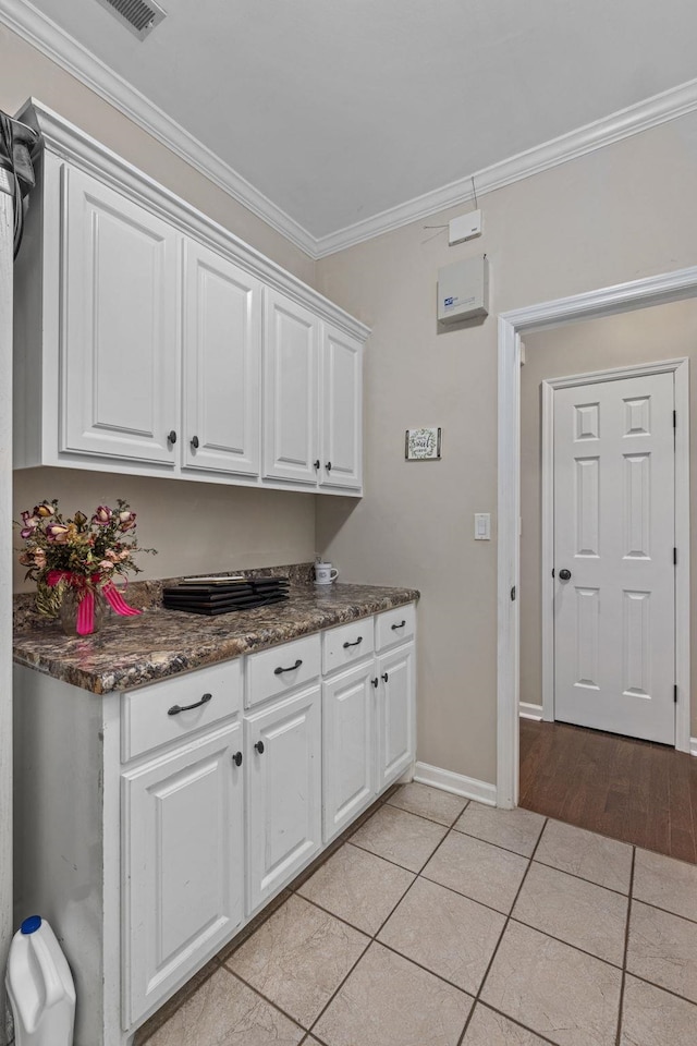  - laundry room with ornamental molding, light tile patterned floors, and baseboards