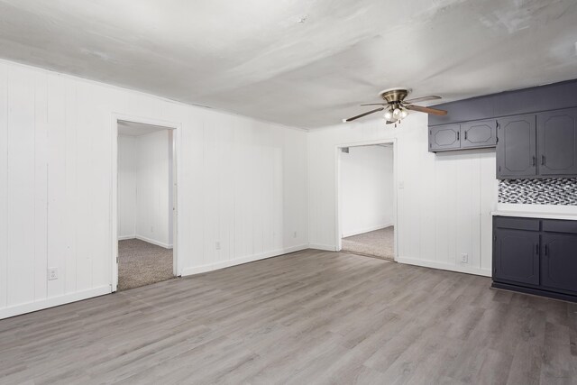  - unfurnished living room with baseboards, ceiling fan, and light wood finished floors