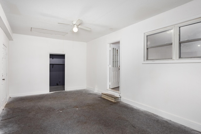  - empty room with carpet floors, ceiling fan, baseboards, and attic access