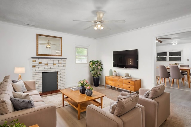  - living room with crown molding, ceiling fan, visible vents, and wood finished floors