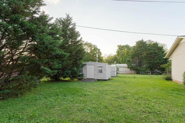  - view of yard with fence, an outdoor structure, and a storage unit