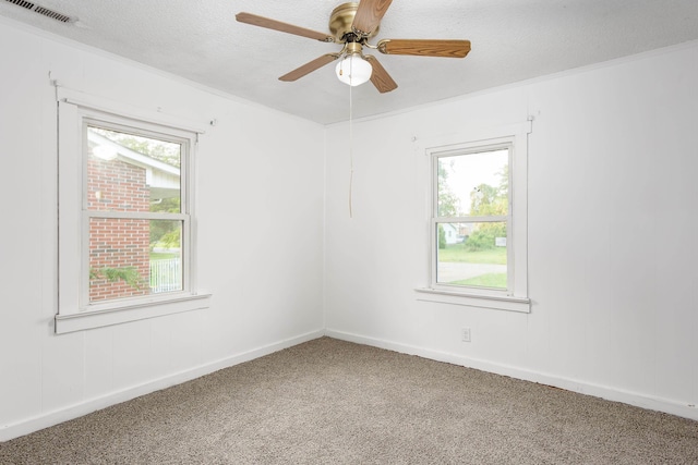  - unfurnished room featuring carpet floors, ceiling fan, visible vents, and a wealth of natural light