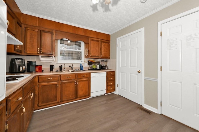 kitchen featuring sink, dark wood-type flooring, a textured ceiling, white appliances, and ornamental molding