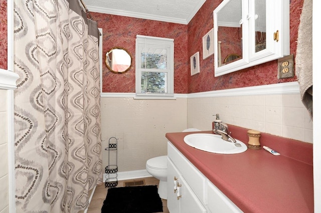 bathroom featuring a textured ceiling, vanity, toilet, and crown molding