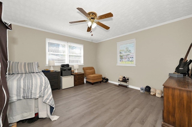 bedroom featuring a textured ceiling, light wood-type flooring, ceiling fan, and crown molding