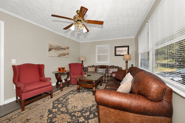 living room with ceiling fan, crown molding, and a textured ceiling