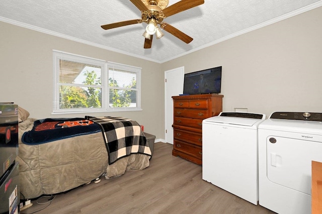 clothes washing area with ornamental molding, a textured ceiling, ceiling fan, independent washer and dryer, and light hardwood / wood-style floors