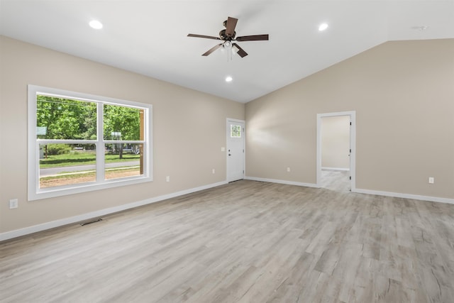 spare room with light hardwood / wood-style flooring, vaulted ceiling, and ceiling fan