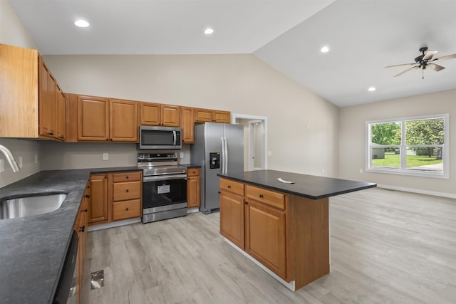 kitchen with ceiling fan, sink, light hardwood / wood-style flooring, a kitchen island, and appliances with stainless steel finishes