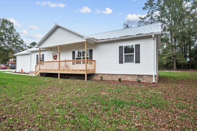 rear view of house with a wooden deck and a yard