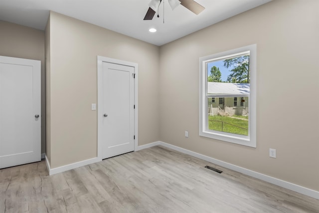 unfurnished bedroom featuring a closet, light hardwood / wood-style flooring, and ceiling fan