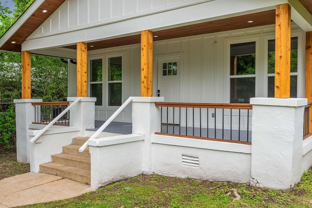 doorway to property with board and batten siding and covered porch