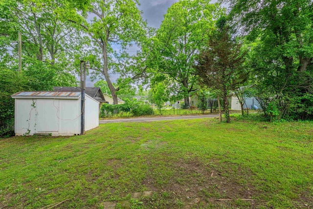 view of green lawn featuring a storage shed and an outbuilding