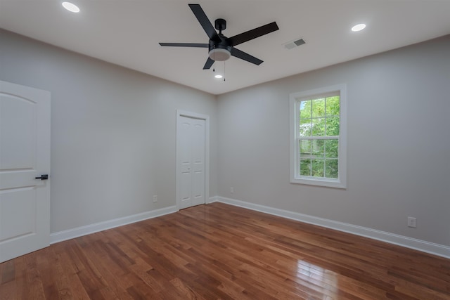 spare room featuring wood finished floors, baseboards, ceiling fan, and recessed lighting