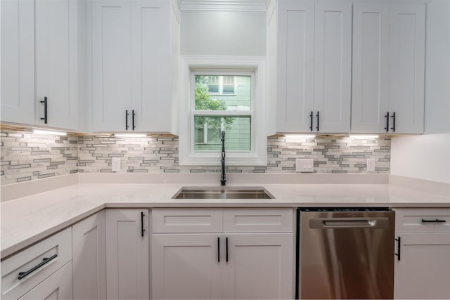 kitchen featuring stainless steel dishwasher, a sink, light countertops, white cabinets, and crown molding