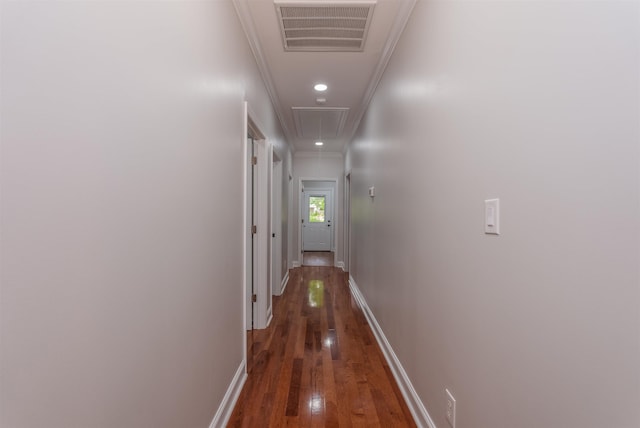 hallway featuring attic access, hardwood / wood-style flooring, baseboards, ornamental molding, and recessed lighting