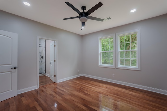 unfurnished bedroom with wood finished floors, baseboards, recessed lighting, ceiling fan, and connected bathroom