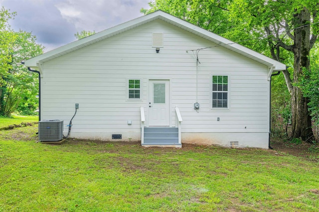rear view of house featuring crawl space, entry steps, a lawn, and central AC unit