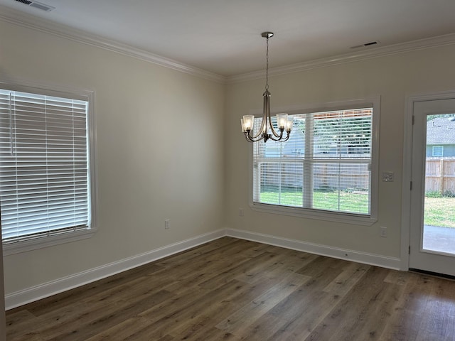 unfurnished dining area featuring a healthy amount of sunlight, dark hardwood / wood-style flooring, crown molding, and a chandelier