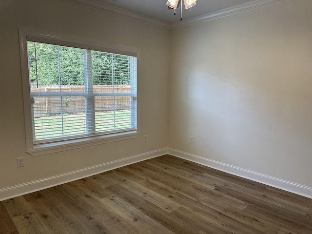 empty room with dark hardwood / wood-style flooring and ornamental molding